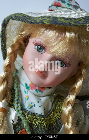 Belle poupée en porcelaine aux longs cheveux blonds en tresses et longs cils Banque D'Images