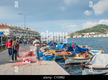 Examinant les filets de pêche Les pêcheurs sur le quai à Foça, en Turquie. Les bateaux de pêche traditionnels sont liés. Banque D'Images