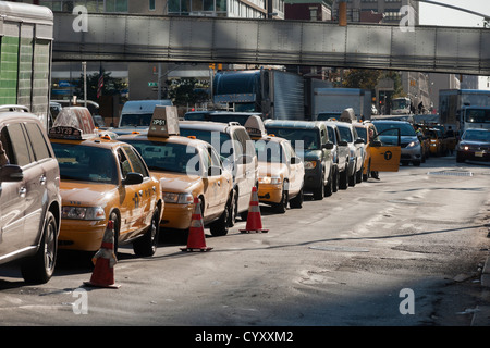 Ligne conducteurs jusqu'à acheter l'essence à une station service à l'Hess quartier Clinton de Manhattan à New York Banque D'Images