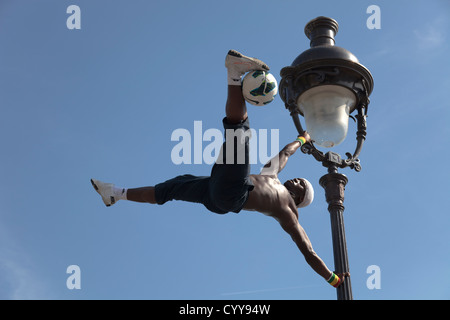 Artiste performance acrobatique sur une vieille lampe de rue sur la colline du Sacré Coeur à Paris Banque D'Images