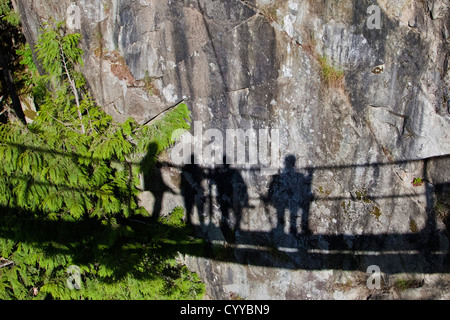 Des ombres sur le rocher ; personnes debout sur le pont suspendu de Capilano jeter une ombre sur le rocher, attraction touristique Vancouver Banque D'Images