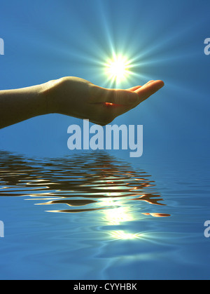 Main tenant le soleil et l'eau reflaction avec copyspace Banque D'Images