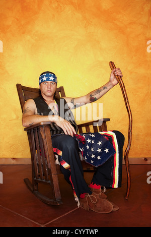 S'agenouillant Native American man in rocking chair Banque D'Images