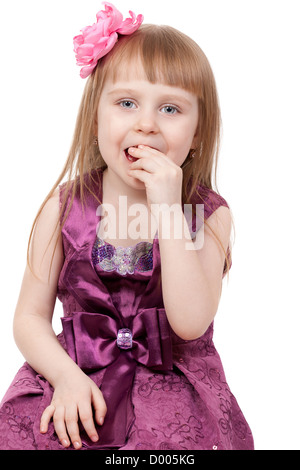 La petite fille mange un jujube. Isolé sur fond blanc Banque D'Images