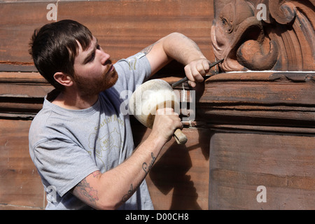 David Carty, un sculpteur sur pierre, la réparation de la sculpture en grès endommagés sur l'entrée principale de l'établissement Fairfield Shipyard, Glasgow Banque D'Images