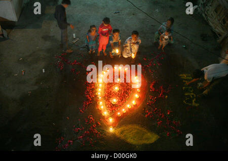 Les enfants hindous lampes en terre eclaircir lors de la cérémonie pour célébrer la fête du Diwali Swami Narayan Temple à Karachi le mardi 13 novembre 2012. La communauté hindoue à travers le Pakistan célèbre leur fête religieuse, Diwali. Les membres de la communauté hindoue éclairés de lampes à huile à l'extérieur des temples, leurs maisons et magasins après laquelle pooja des cérémonies ont été organisées au niveau des tempes. Le triomphe du bien sur le mal, coloré rangolis (des motifs réalisés par les couleurs) et les pétards sont les points forts de la fête hindoue. Banque D'Images