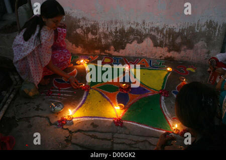 Fille hindoue lampes en terre eclaircir lors de la cérémonie pour célébrer la fête du Diwali Swami Narayan Temple à Karachi le mardi 13 novembre 2012. La communauté hindoue à travers le Pakistan célèbre leur fête religieuse, Diwali. Les membres de la communauté hindoue éclairés de lampes à huile à l'extérieur des temples, leurs maisons et magasins après laquelle pooja des cérémonies ont été organisées au niveau des tempes. Le triomphe du bien sur le mal, coloré rangolis (des motifs réalisés par les couleurs) et les pétards sont les points forts de la fête hindoue. Banque D'Images