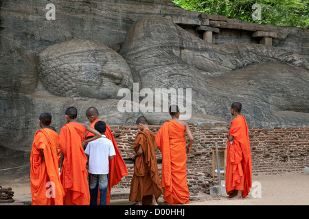 Les moines novices en contemplant un bouddha couché. Gal Vihara. La ville ancienne de Polonnaruwa. Sri Lanka Banque D'Images