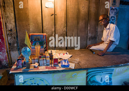 Homme avec petite cabine de bordure de vendre des cigarettes dans la nuit, Kanjippadom, près de Alappuzha (Alleppey), Kerala, Inde Banque D'Images