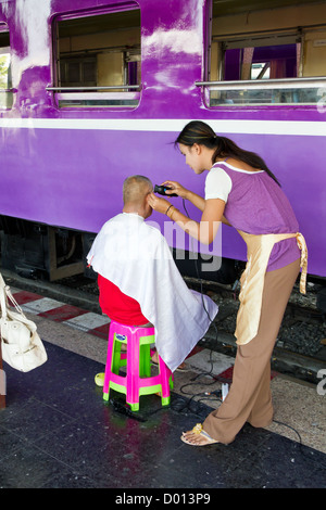 Couper les cheveux en quatre sur une plate-forme de la gare centrale de Bangkok, Thaïlande Banque D'Images