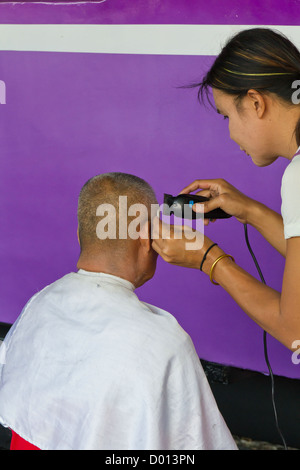 Couper les cheveux en quatre sur une plate-forme de la gare centrale de Bangkok, Thaïlande Banque D'Images