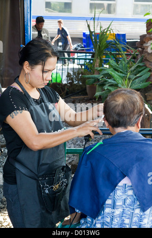 Couper les cheveux en quatre sur une plate-forme de la gare centrale de Bangkok, Thaïlande Banque D'Images