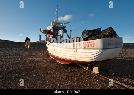 Un petit bateau de pêche chargé de marmites de homard, qui est enroulée sur la plage de bardeaux à Deal, Kent, Royaume-Uni Banque D'Images