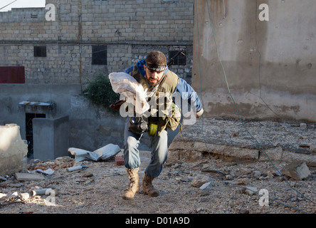 26 octobre 2012 - Alep, Syrie : un membre de l'Armée syrienne libre passe devant un sniper en position de Safa. Banque D'Images