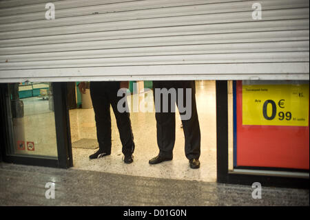 La Ramblas, Barcelone, Catalogne, Espagne. 14 novembre 2012. Les agents de sécurité derrière les volets d'une boutique. La grève générale en Espagne contre les coupes sociales et la réforme du travail a changé le look de la foule Rambla, la principale destination touristique dans la ville de Barcelone. Crédit : Jordi Boixareu / Alamy Live News Banque D'Images