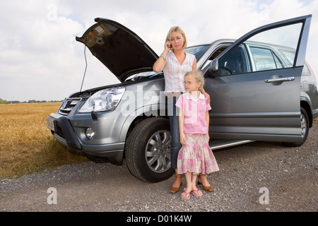 Mère et fille debout à côté de la voiture en panne Banque D'Images