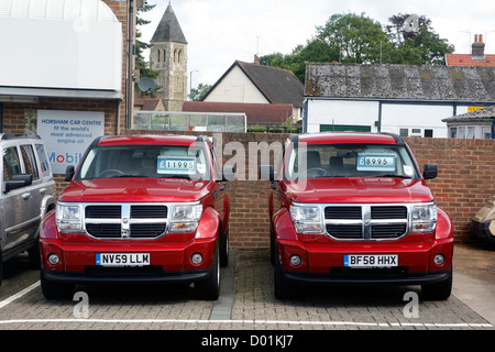 Deux grandes voitures garées à côté de l'autre dans un parking. Banque D'Images