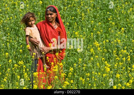 Femme et enfant dans le champ de la moutarde près de Rajasthan en Inde Kelashdi Banque D'Images