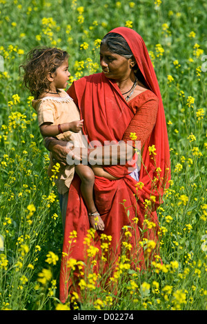 Femme et enfant dans le champ de la moutarde près de Rajasthan en Inde Kelashdi Banque D'Images