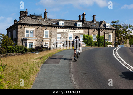 Des montées cyclistes Ilkley colline en direction de la vache et du veau Hotel, West Yorkshire, Royaume-Uni Banque D'Images