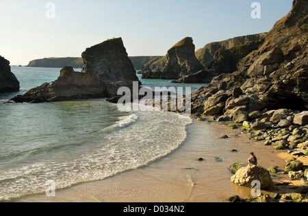 Bedruthan steps Beach, femme assise sur un rocher, North Cornwall, England, UK Banque D'Images