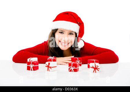 Beautiful Asian woman wearing Santa hat avec de petits cadeaux de Noël, isolated on white Banque D'Images