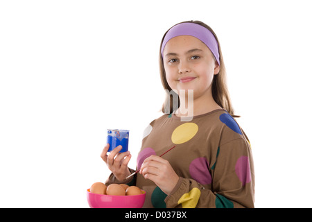 Adorable fille ornant les oeufs de Pâques sur un over white background Banque D'Images