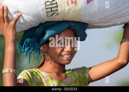 Young woman walking avec grande tête de paquet sur l'Inde Banque D'Images