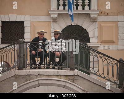 Gondoliers siéger en attente d'affaires par les canaux du quartier Castello de Venise Italie en automne Banque D'Images