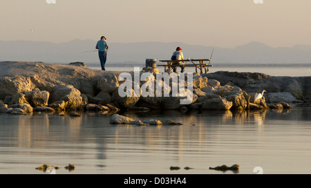 États-unis, Californie, Salton Sea. Pêche Les hommes au coucher du soleil dans la mer de Salton. Banque D'Images