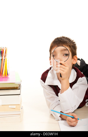 Garçon à la loupe par l'école et faire ses devoirs Banque D'Images