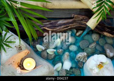 L'eau qui tombe sur des pierres spa concept historique d'orchidées et de bambou Banque D'Images