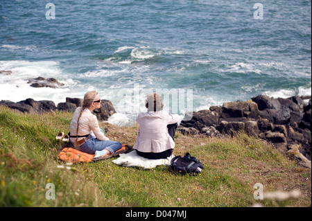 Deux femmes vacanciers appréciant un reste sur le south west coast path, England uk Banque D'Images