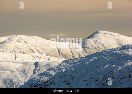 La neige sur les collines de Kentmere éboulis rouge dans le Lake District. Banque D'Images