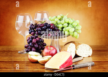 Dutch Edam fromage avec fruits frais, une miche de pain de grains entiers et de verres d'eau. Banque D'Images