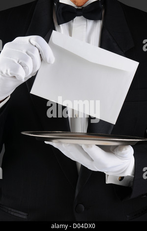 Libre d'un majordome vêtu d'un tuxedo holding a silver tray et une enveloppe. Format vertical, l'homme est méconnaissable. Banque D'Images