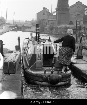 Femme prenant un canal à bord d'un bateau à rames à travers une écluse dans le Black Country West Midlands UK en 1959. Grande-Bretagne les femmes des années 50 travaillent canal voies navigables eau gitans tziganes Banque D'Images