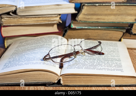 De vieux livres avec des verres sur la table en bois Banque D'Images