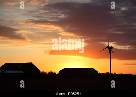 Coucher de soleil avec petite éolienne découpé sur un ciel orange, vu l'été dans l'East Yorkshire Banque D'Images