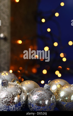 Boules de Noël argent avec lumières dorées sur fond bleu Banque D'Images