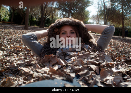 Femme enfouie dans les feuilles de chêne Banque D'Images