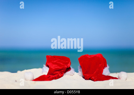 Deux rouge Santa hats on beach Banque D'Images