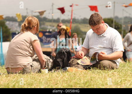 Festival de Glastonbury couple homme et femme festival de musique à programme de lecture Banque D'Images