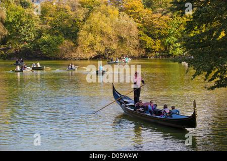 L'aviron dans la gondole Gondolier Central Park Lake avec d'autres bateaux à rame à l'arrière-plan, New York, USA Banque D'Images