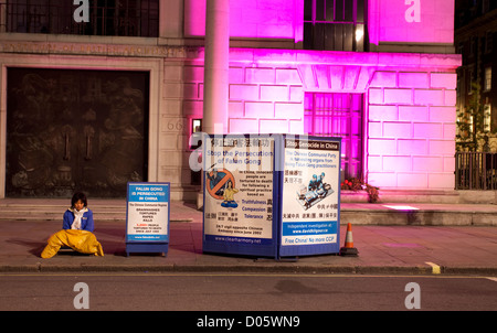 Le Falun Gong manifestant est assis sur le trottoir en face de l'ambassade de Chine à Portland Place, London, England, UK Banque D'Images