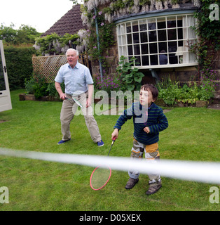 Grand-parent à jouer au badminton dans le jardin avec son petit-fils dans le North Yorkshire, uk Banque D'Images