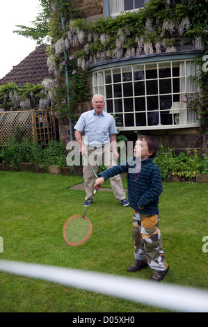 Grand-parent à jouer au badminton dans le jardin avec son petit-fils dans le North Yorkshire, uk Banque D'Images