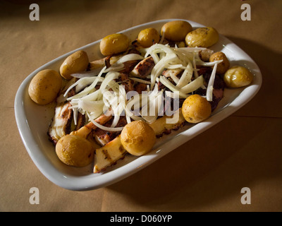 Plat typiquement portugais à Lagareiro Polvo - poulpe cuit avec des pommes de terre et arrosé d'huile d'olive, l'ail et les oignons Banque D'Images