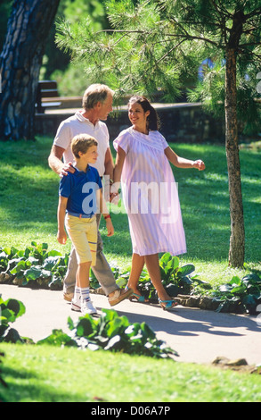 Couple avec femme enceinte et garçon promenade dans park Banque D'Images