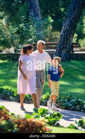 Couple avec femme enceinte et garçon promenade dans park Banque D'Images